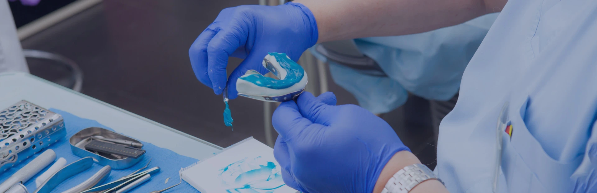 A close up of gloved hands showing how dentures are made.