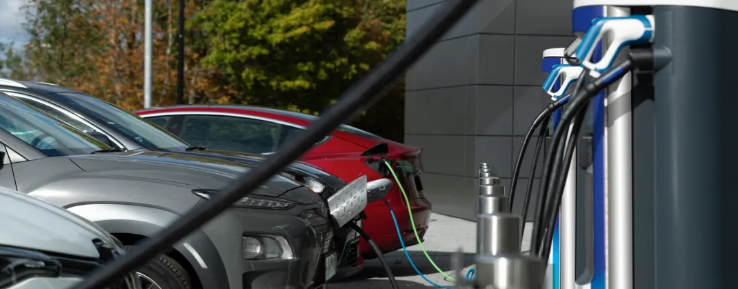 Four EVs lined up and charging in a communal charging space. 