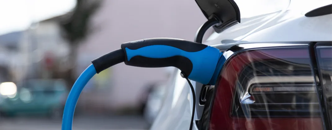 An EV charger is plugged to a vehicle for charging.