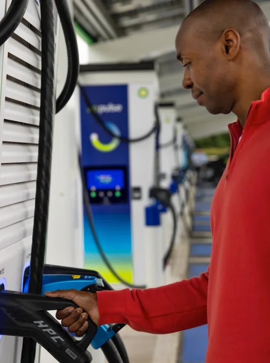 Man selecting a charging plug at a bp pulse charging station.