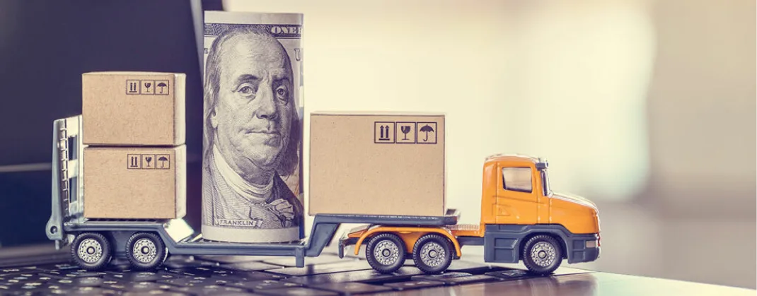 A toy van holding a rolled up dollar note. 