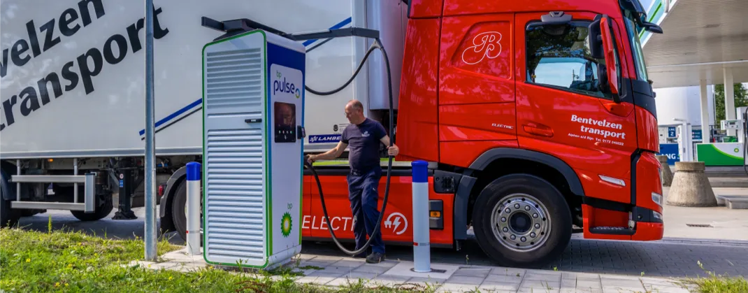A man near a bp pulse charger with his transport truck.