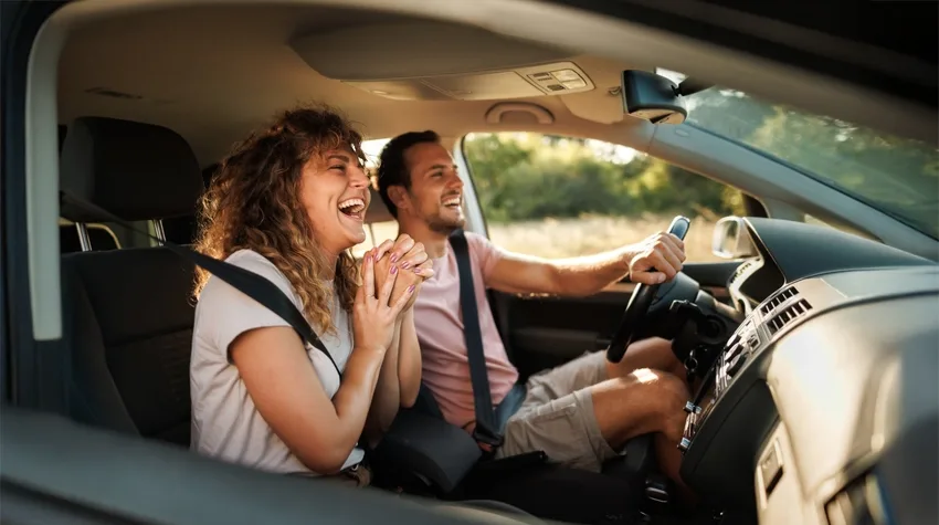 Man and lady driving ev car in summer