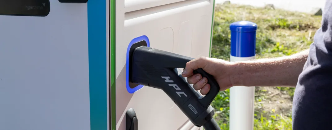 A male hand holding a charger handle, about to take it out of the machine. 