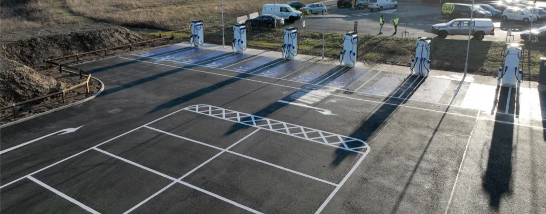 Six bp pulse chargers in a parking lot, not being used, during the daytime. 
