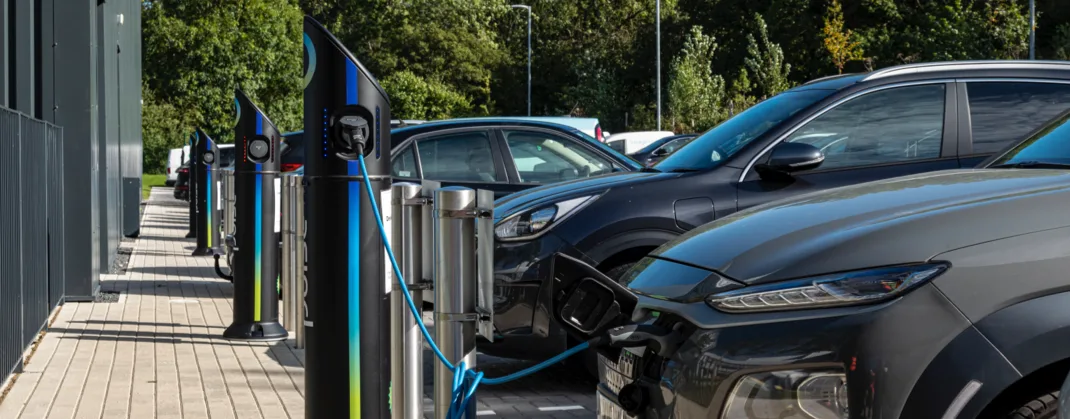 Electric vehicles charging at a row of bp pulse stations, easily accessed and conveniently located outside an office building.
