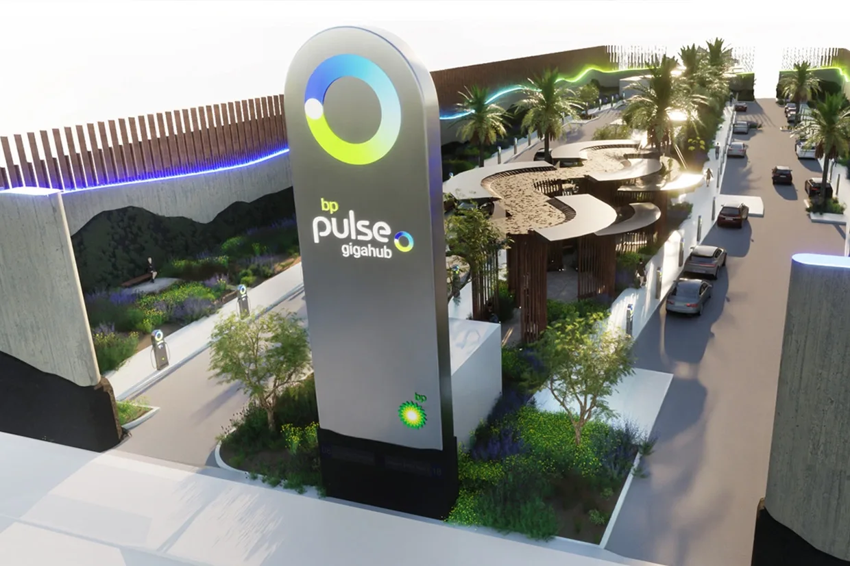A large EV charging forecourt is shown with a large 'bp pulse gigahub' sign at the front. 
