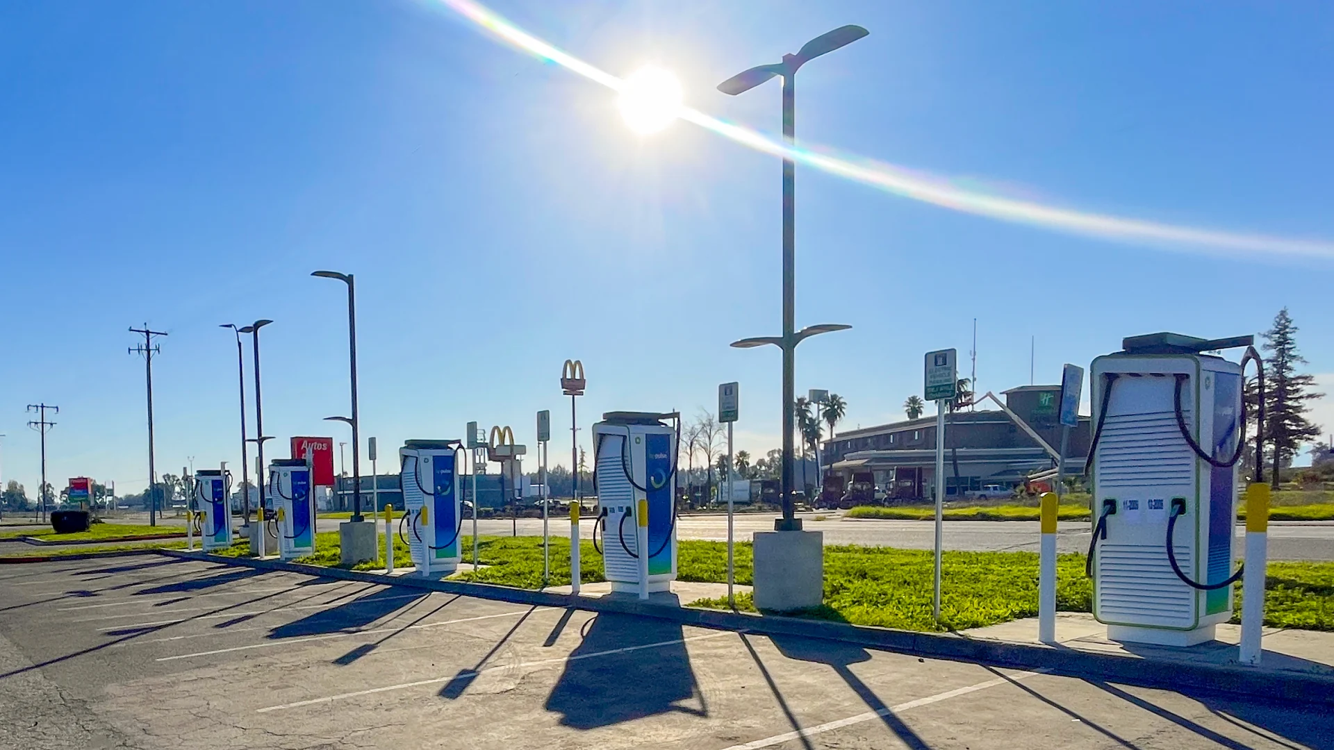 A row of high‑power EV charging points in a car park on a clear, sunny day, offering convenient charging for drivers on the go.