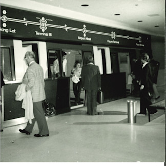 Passengers board an early WEDway train through platform and vehicle doors designed to operate together. The automated system could move travelers without a driver aboard each train.