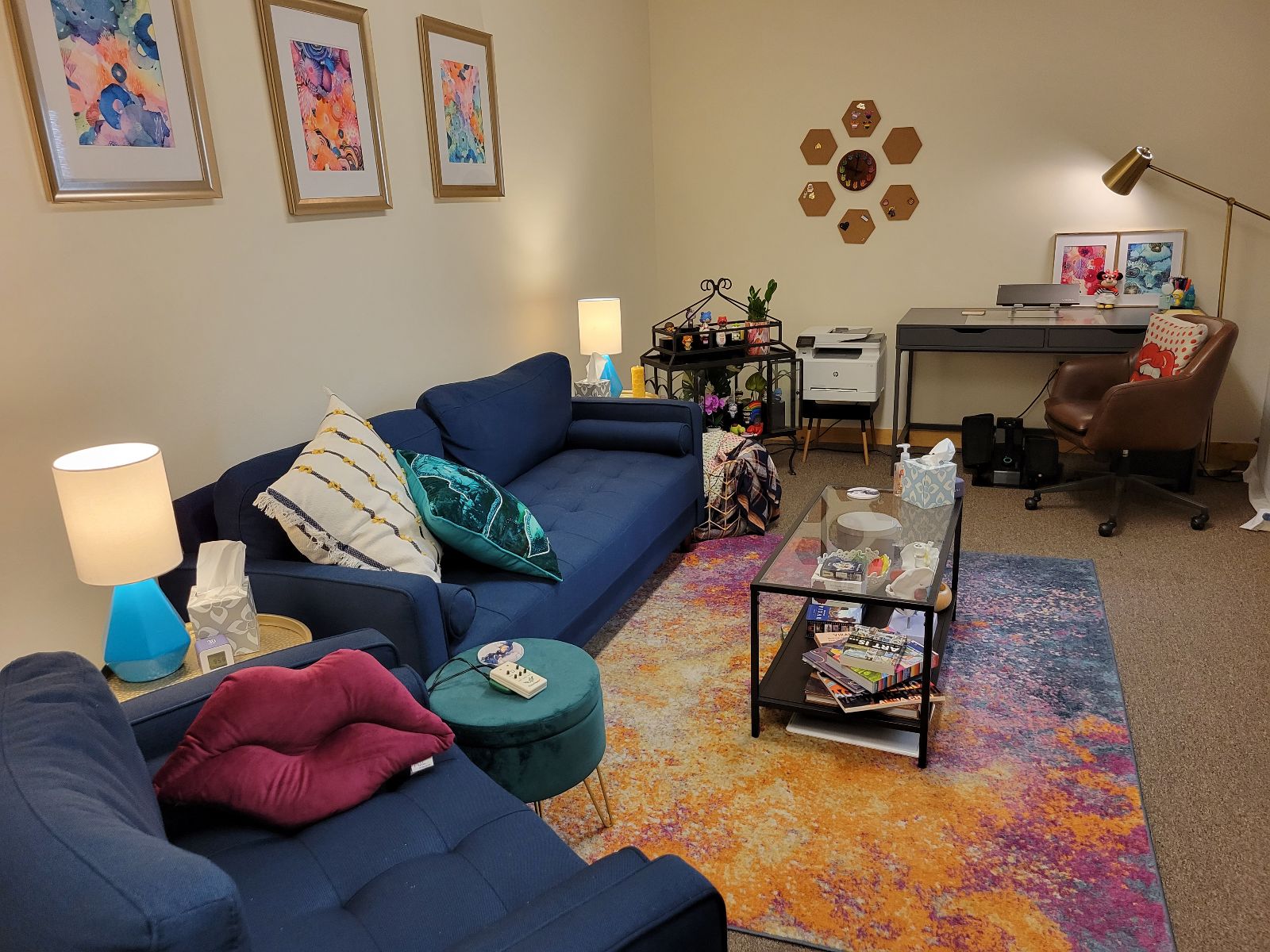 A wide view of the office with couch, desk, chair, and coffee table. 