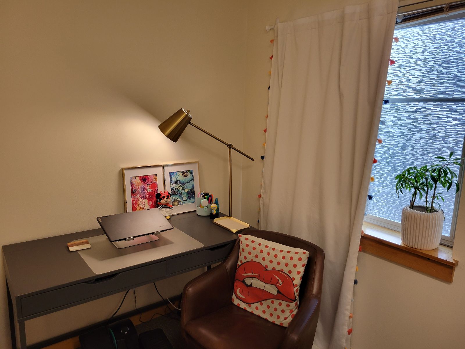 View of desk with chair next to a window. 