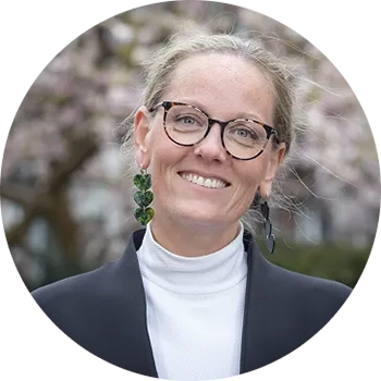 Portrait en extérieur de Hanneke Spruyt-Panbakker souriante regardant droit dans l'objectif.