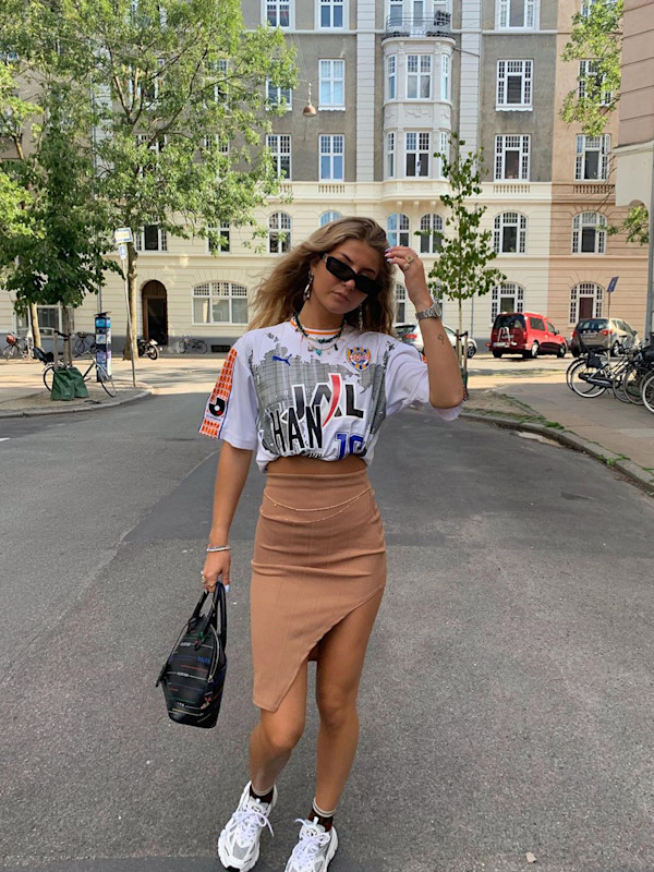 Mit asymmetrischem Rock und Print-Shirt