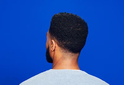 ack of a man’s head, on a blue background. Back of a man’s head, on a blue background.
