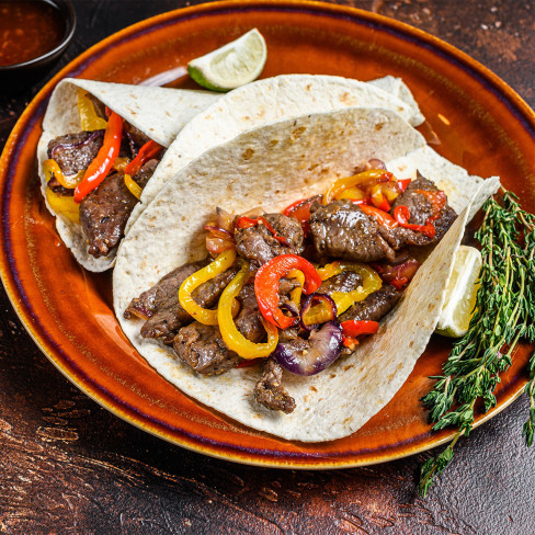 A plate of grilled mexican-style steak and pepper wrap