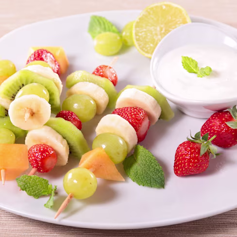 A plate of Glazed Fruit Skewers with Strawberry Yogourt Dip