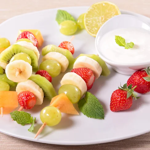 A plate of Glazed Fruit Skewers with Strawberry Yogourt Dip
