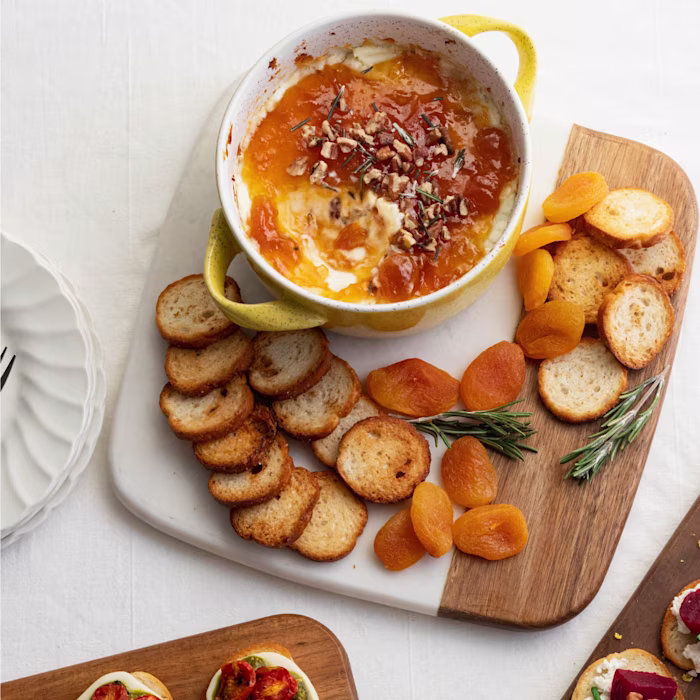 Image of baked goat gheese and apricot dip on a wooden board