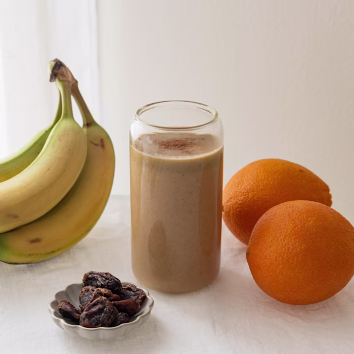 Image of oranges, bananas and dates with a smoothie glass