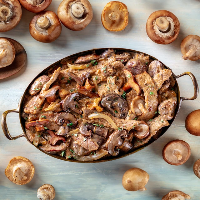 Aerial view of Beef Stroganoff in pot surrounded by mushrooms