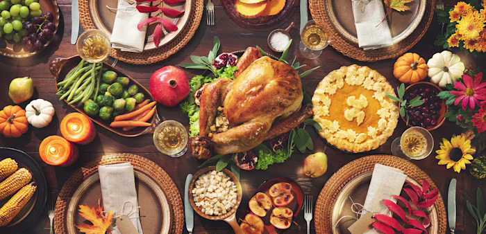 Image of a Thanksgiving celebration traditional dinner with turkey, vegetables and pumpkin pie