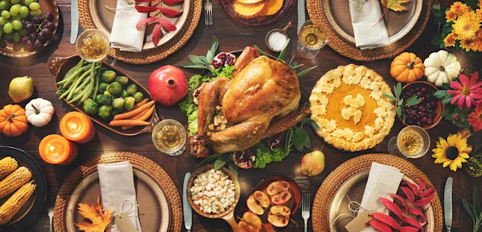 Image of a Thanksgiving celebration traditional dinner with turkey, vegetables and pumpkin pie