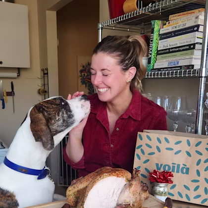 Chef Jill and her dog next to a sliced turkey