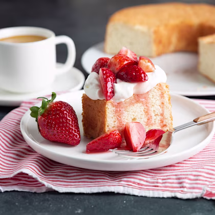 A plate with a slice of Angel Food Cake with Strawberry Buttercream