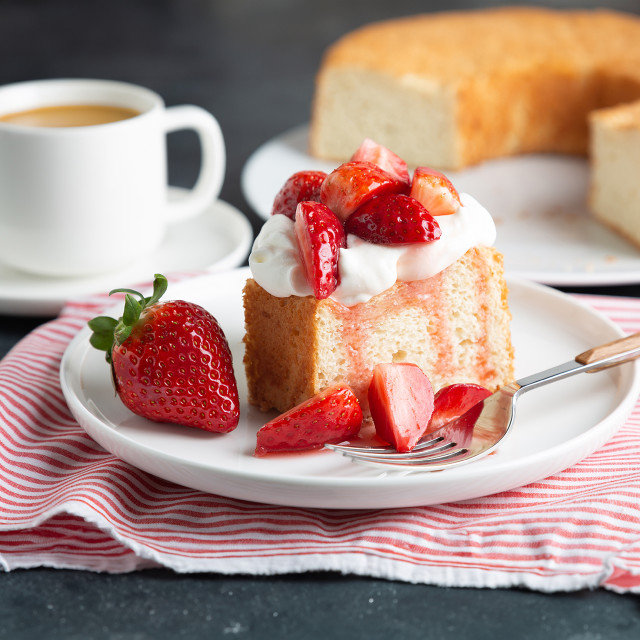 A plate with a slice of Angel Food Cake with Strawberry Buttercream