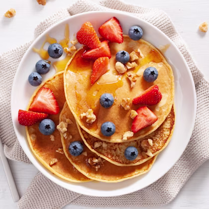 Plate of gluten-free pancakes with a bol of blueberries