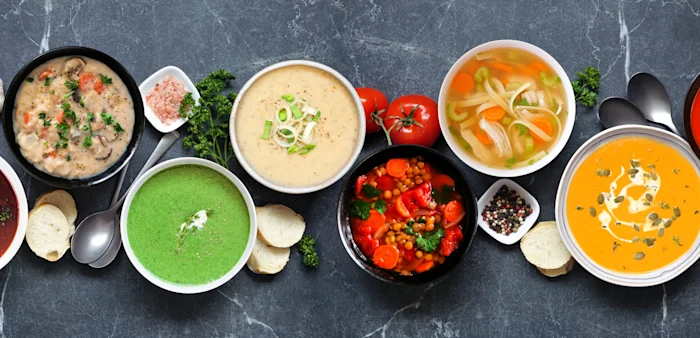 Image of a variety of homemade soups on a dark slate background