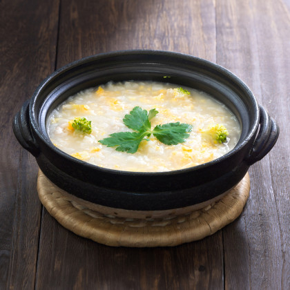 Bowl of corn congee with broccolini
