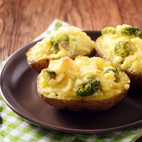 Three twice baked potatoes on round black plate