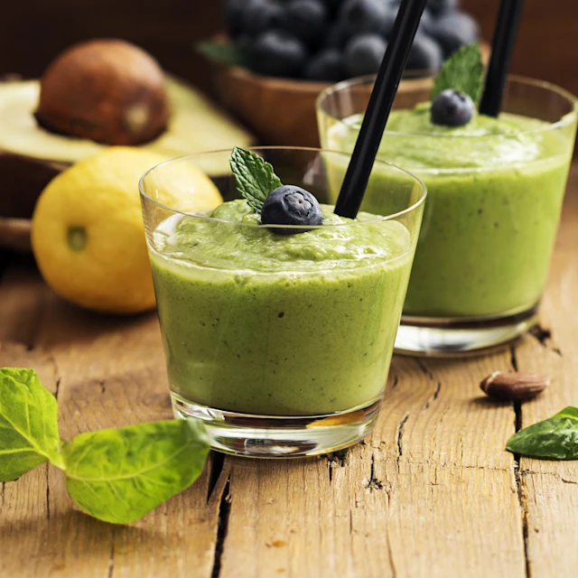 Two glasses of greens, blueberry and fruit smoothie