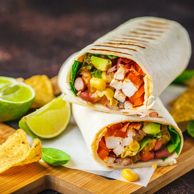A plate of grilled chicken and corn burrito