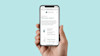 hand holding iphone 10 with overalls web app on screen
