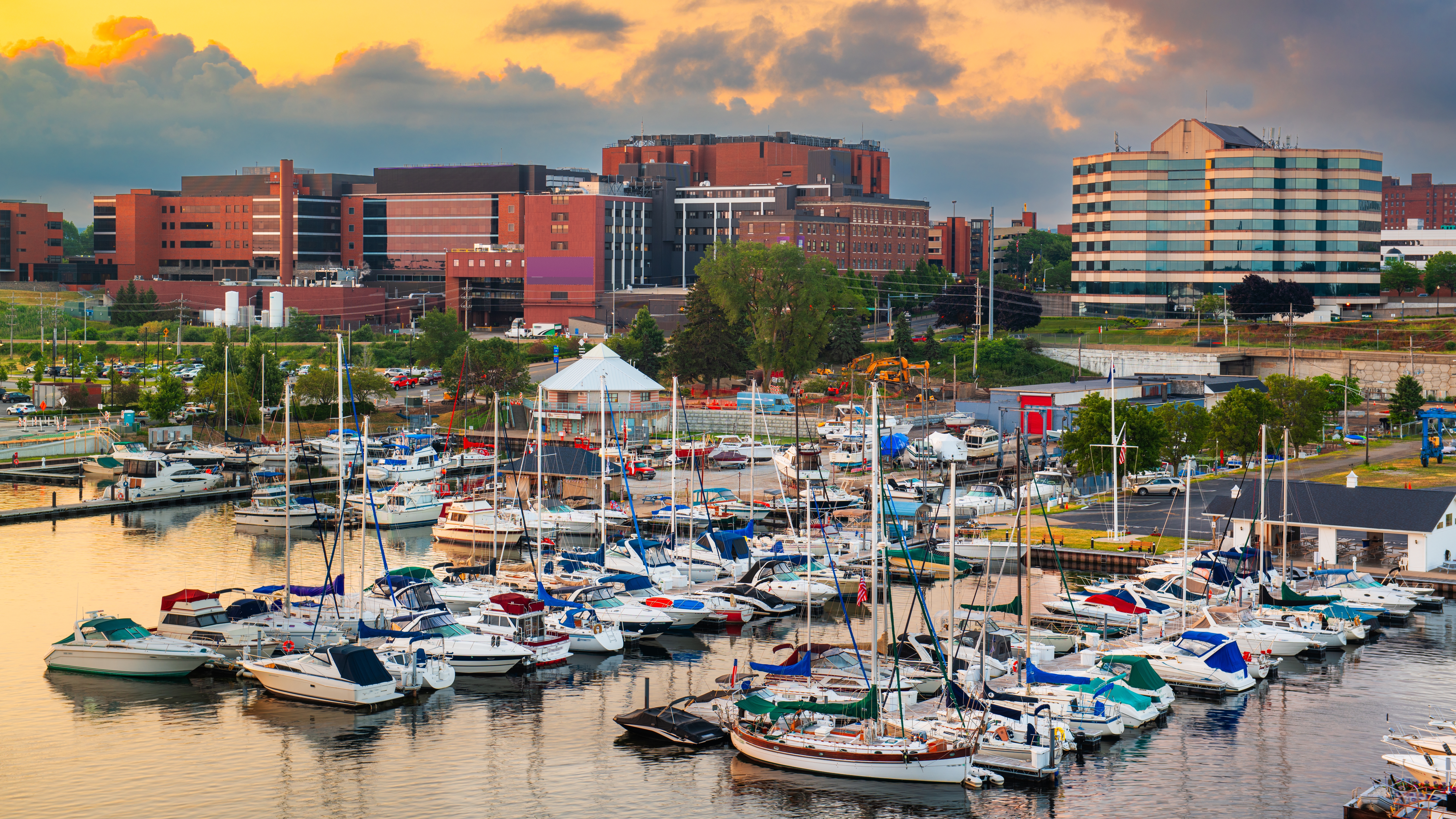 A harbor with boats in the water with buildings in the background