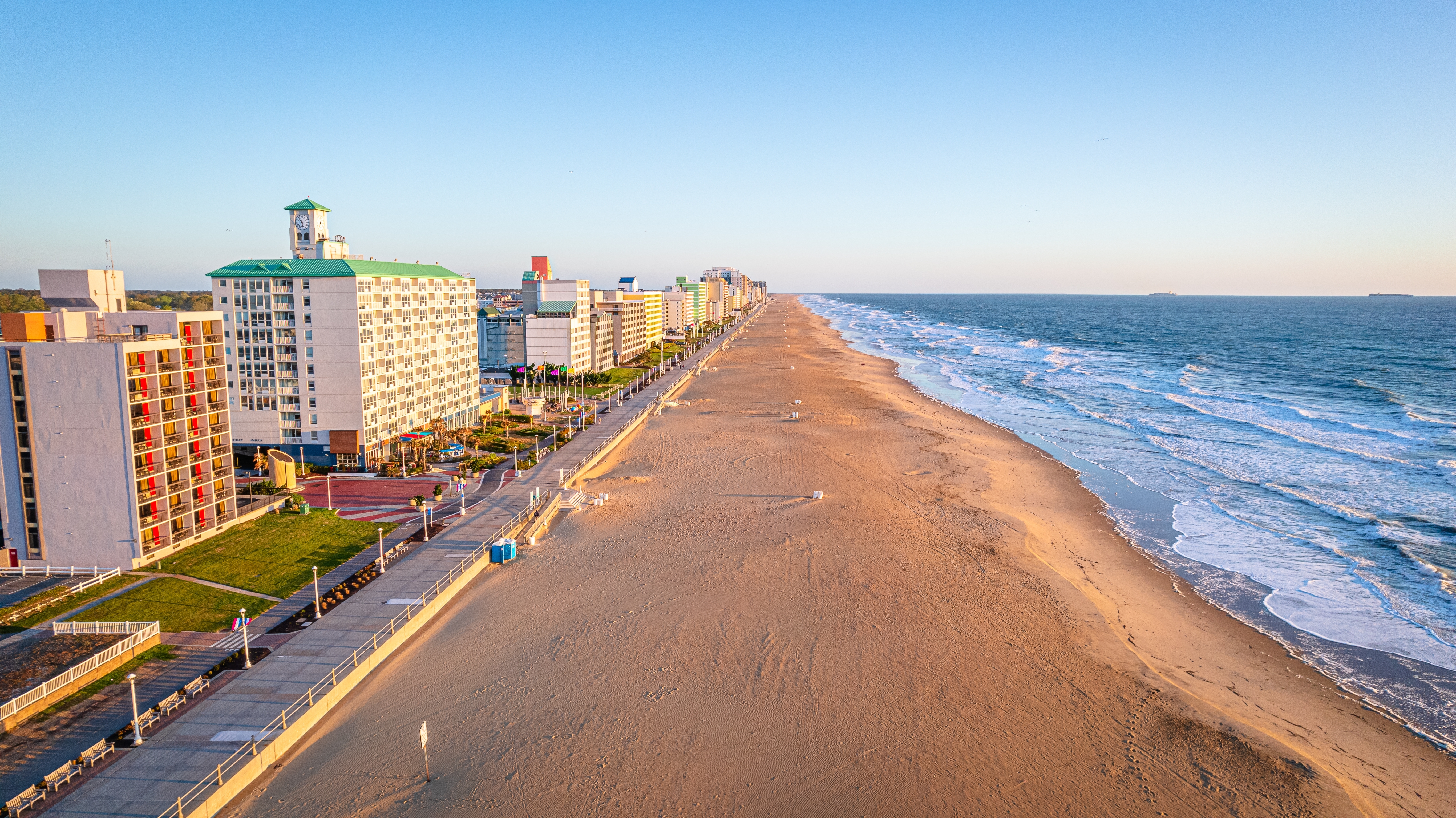 Aerial view of a beach and ocean with buildings on the left side