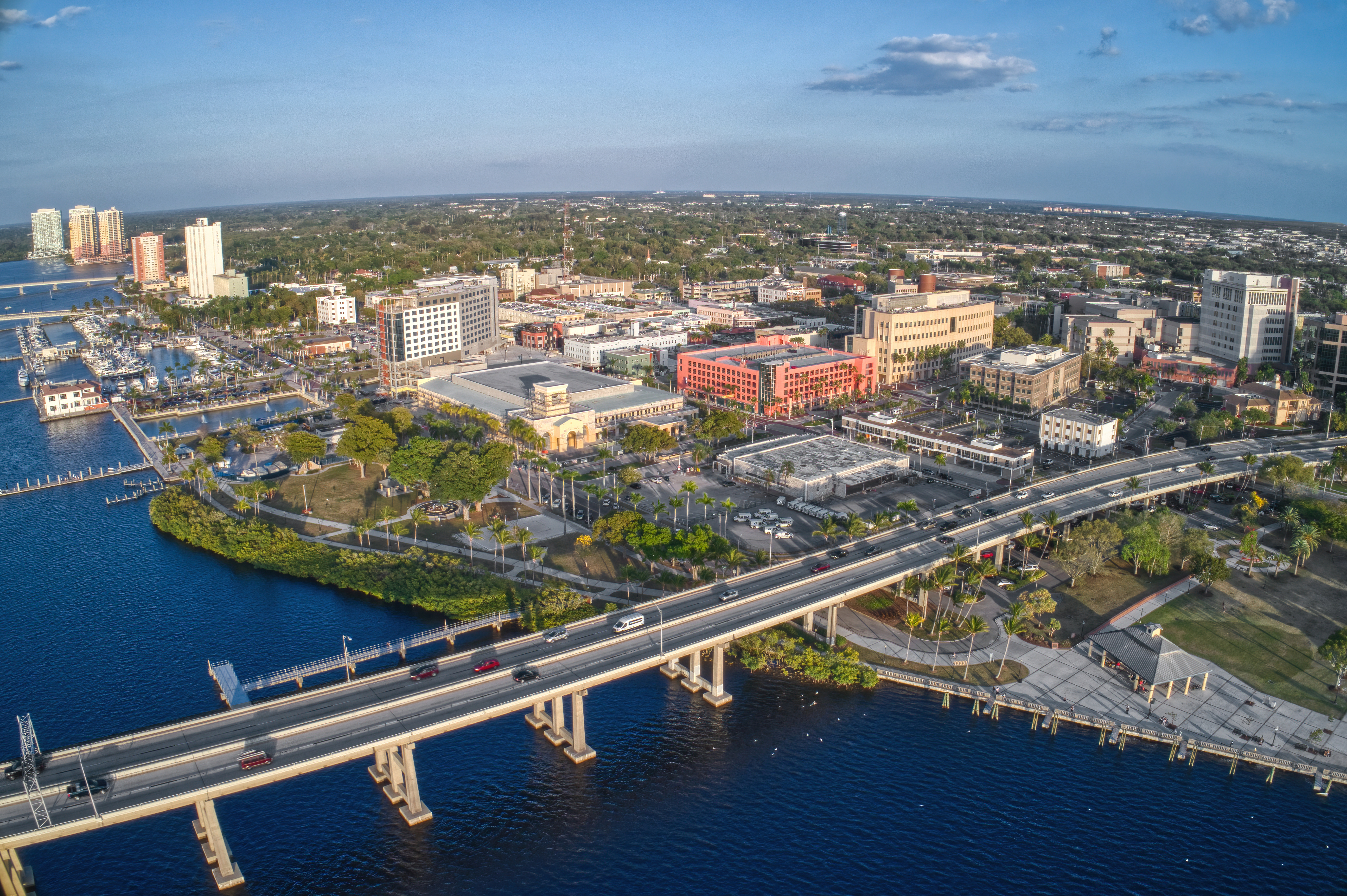 Aerial image of the coast of Fort Myers, FL during day time, with blue skies and minimal clouds.