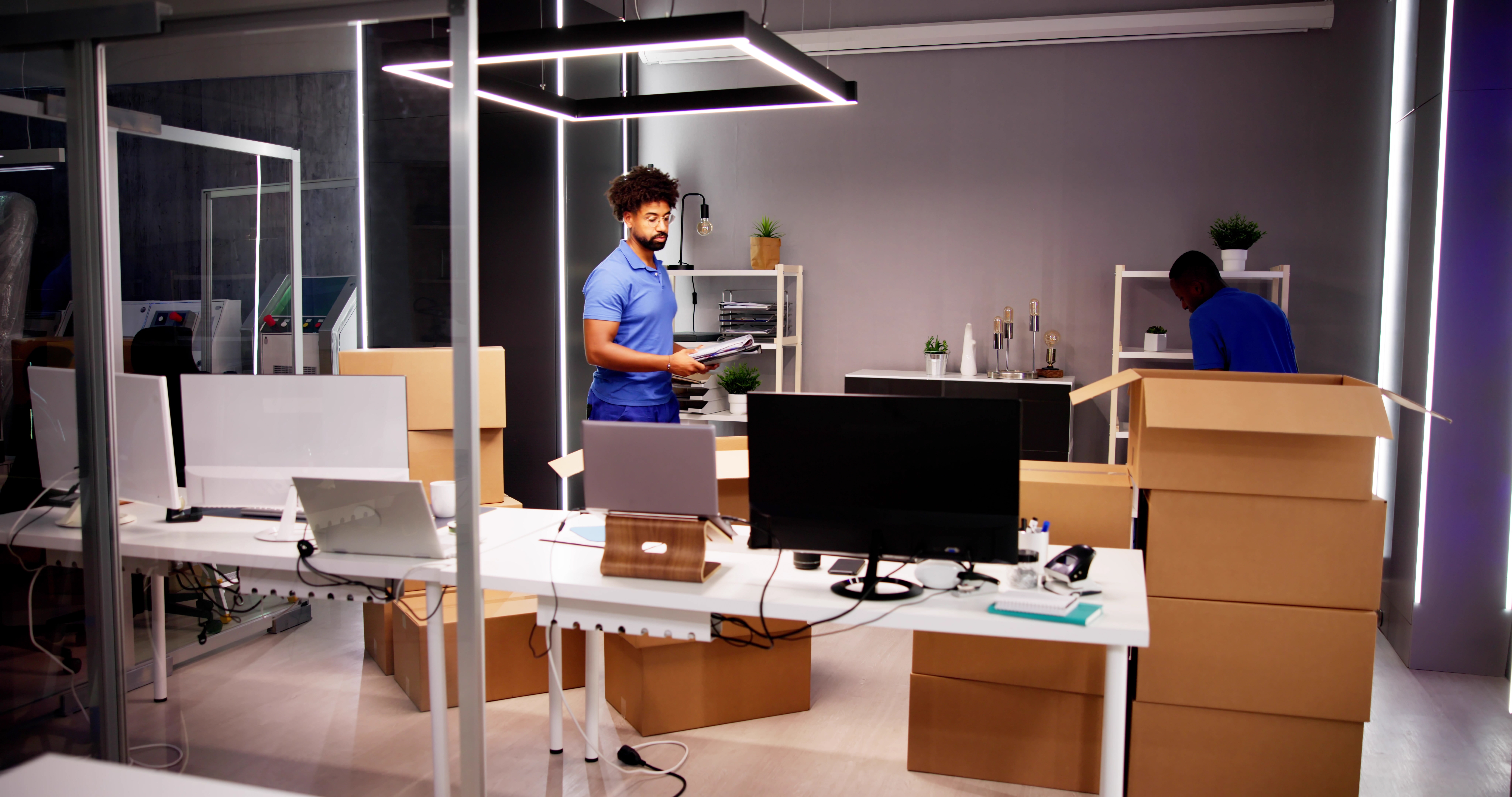 A man standing in a brightly lit office with boxes and a desk