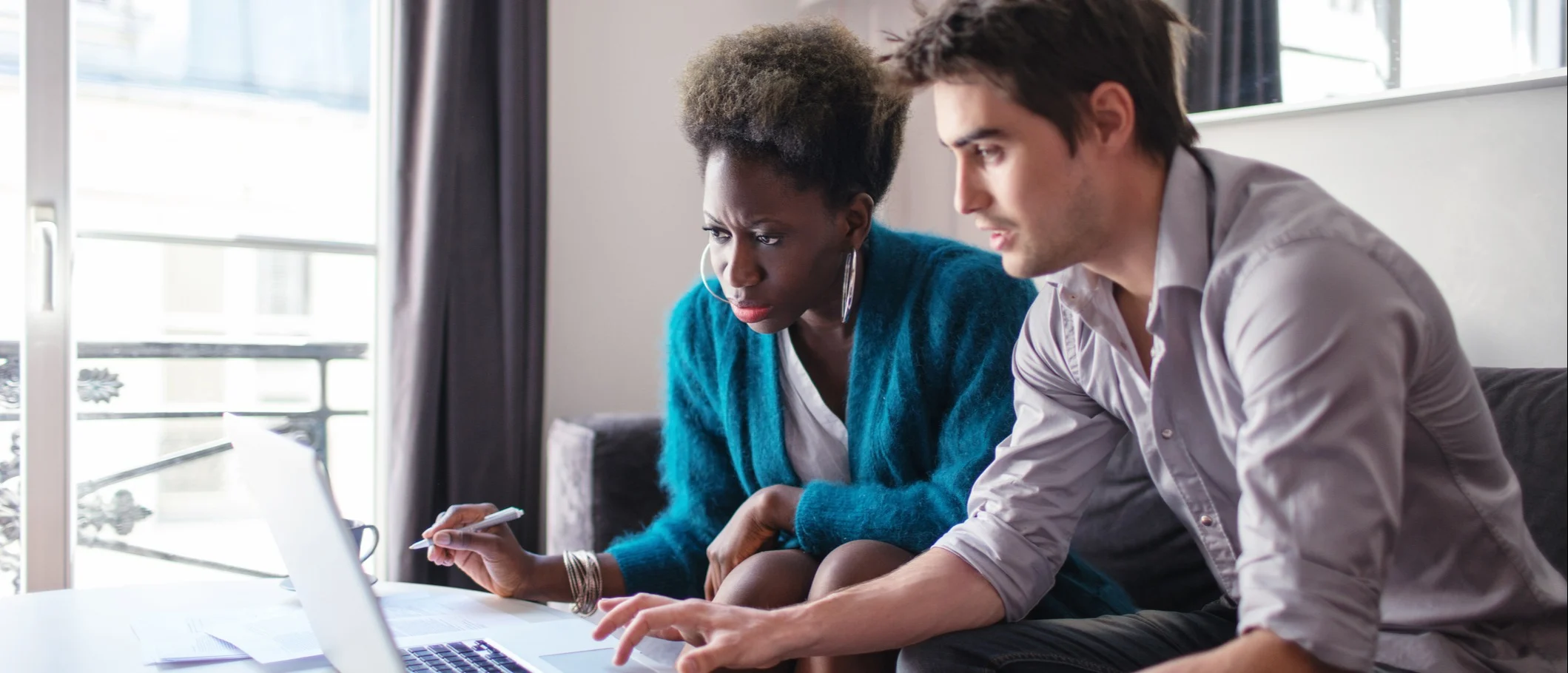 Un couple qui vérifient sur leur ordinateur quelles sont les conditions pour renégocier leur assurance emprunteur.