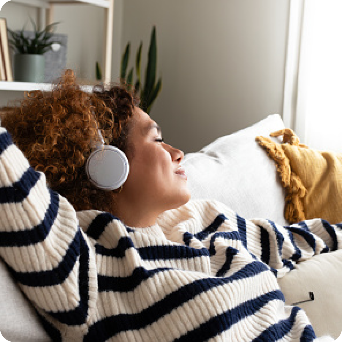 Femme qui écoute de la musique sur un canapé