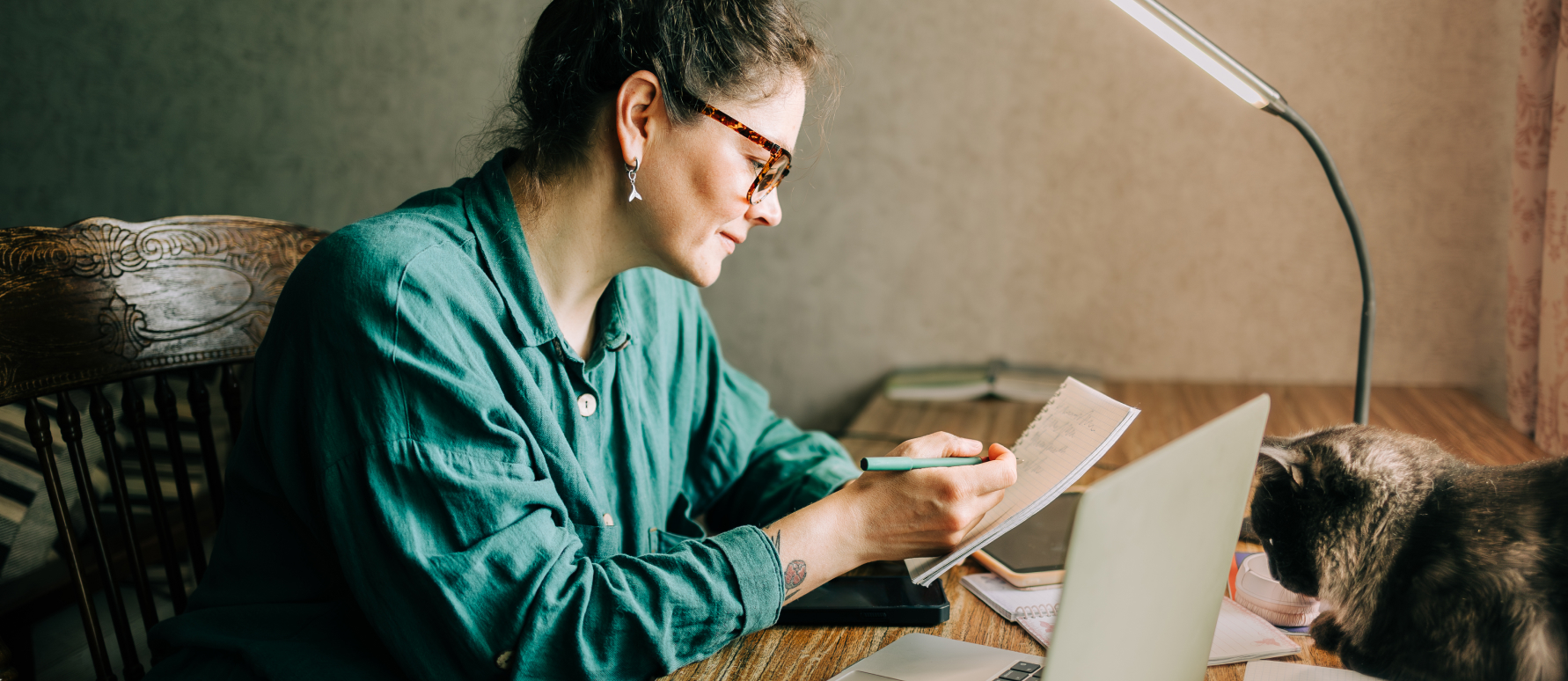 Une femme consulte son ordinateur pour identifier les nouveautés fiscales liées au PER tout en prenant des notes.