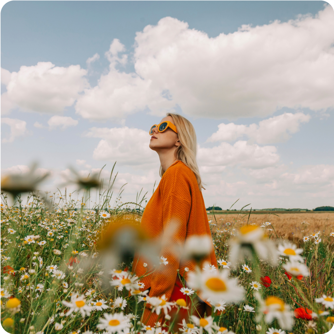 Jeune femme qui se balade dans un champ de pâquerettes