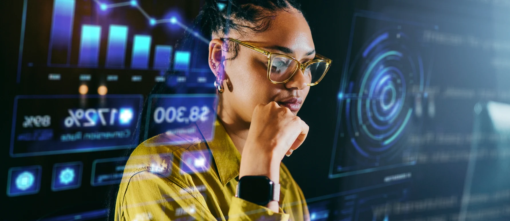 Une jeune femme avec des lunettes consultent plusieurs graphiques boursiers en lien avec son compte-titres.