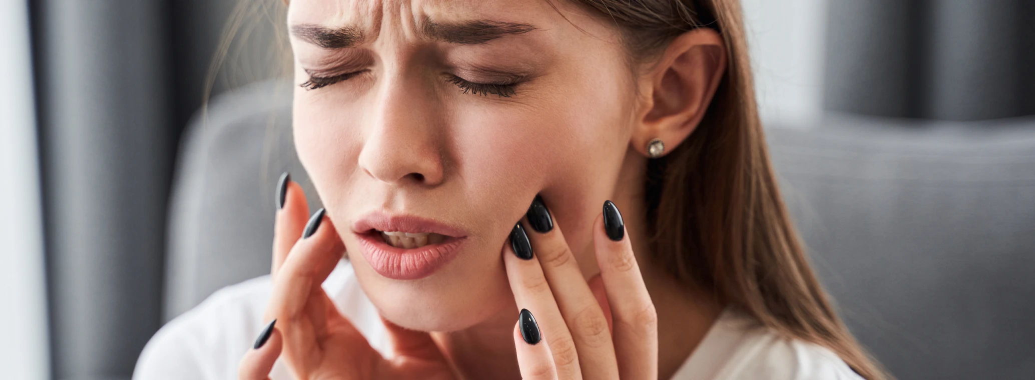 A person experiencing tooth pain possibly due to a cavity or tooth decay | Crest