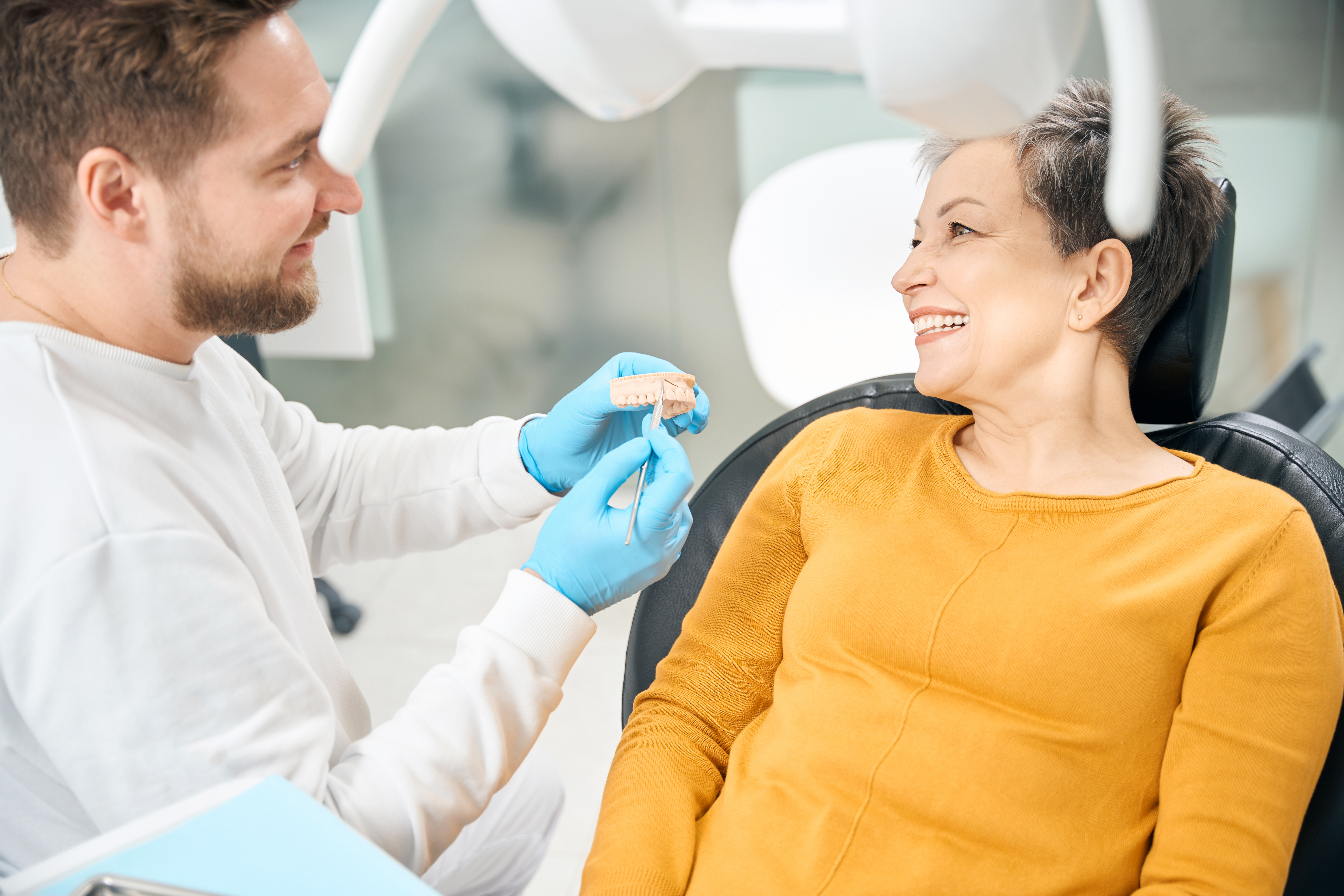 Dentist examining a patient's mouth whilst she smiles