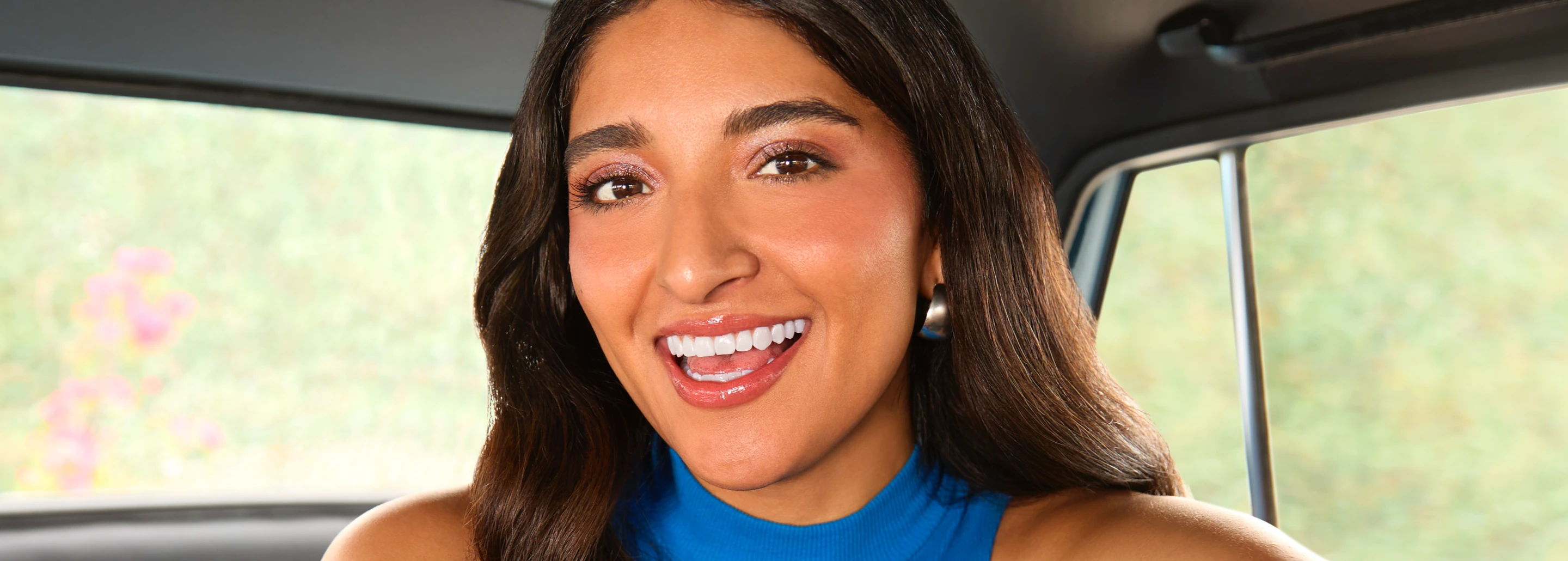 Image of a woman smiling inside a car