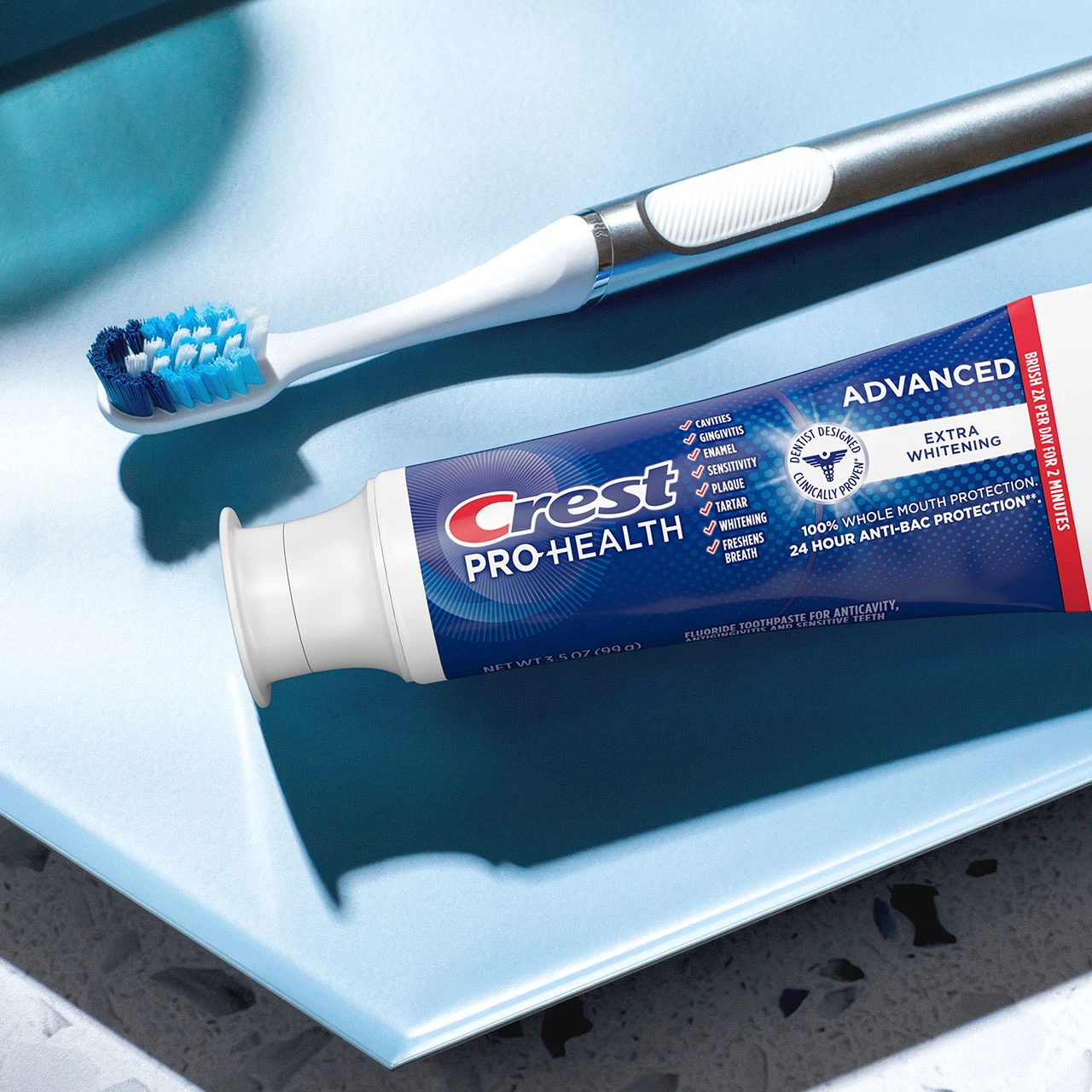 Crest Pro-Health Advanced Extra White Toothpaste and a toothbrush on a counter