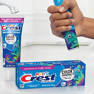 Crest Kids’ Color Changing Toothpaste package and child holding kids Oral-B toothbrush